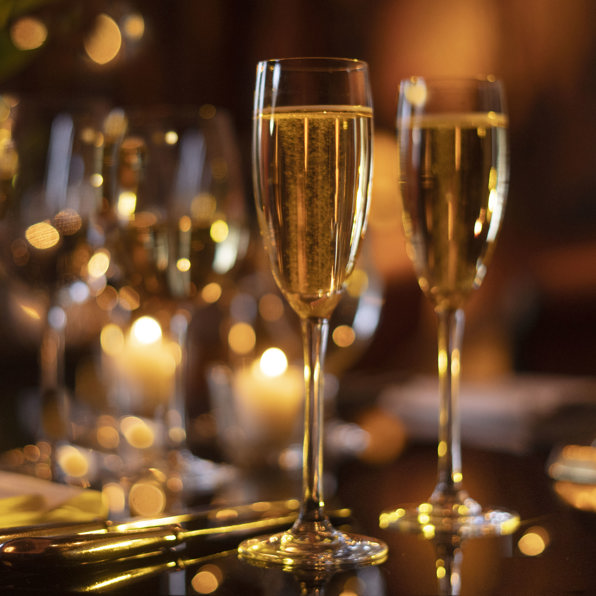 Champagne flutes filled with champagne, silver cutlery and candlesticks on a private dining room table in Prestonfield 