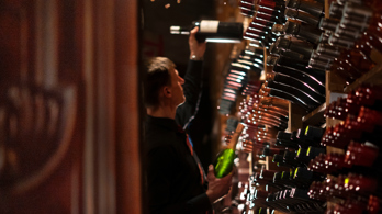 Wine racks and sommelier holding a bottle in the cellar at the Best Edinburgh restaurant for fine wines 