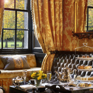 Afternoon tea 3 tier cake stand and champagne in flutes in the Yellow Room at Prestonfield House luxury Edinburgh hotel