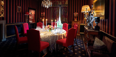 Candles lit and table set with red velvet background in The Stuart private dining room in Edinburgh at Prestonfield House 