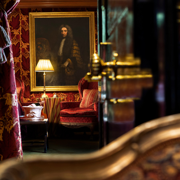 Painting and antique lamp surrounded by maroon velvet during Prestonfield House luxury DBB deal stay in Edinburgh